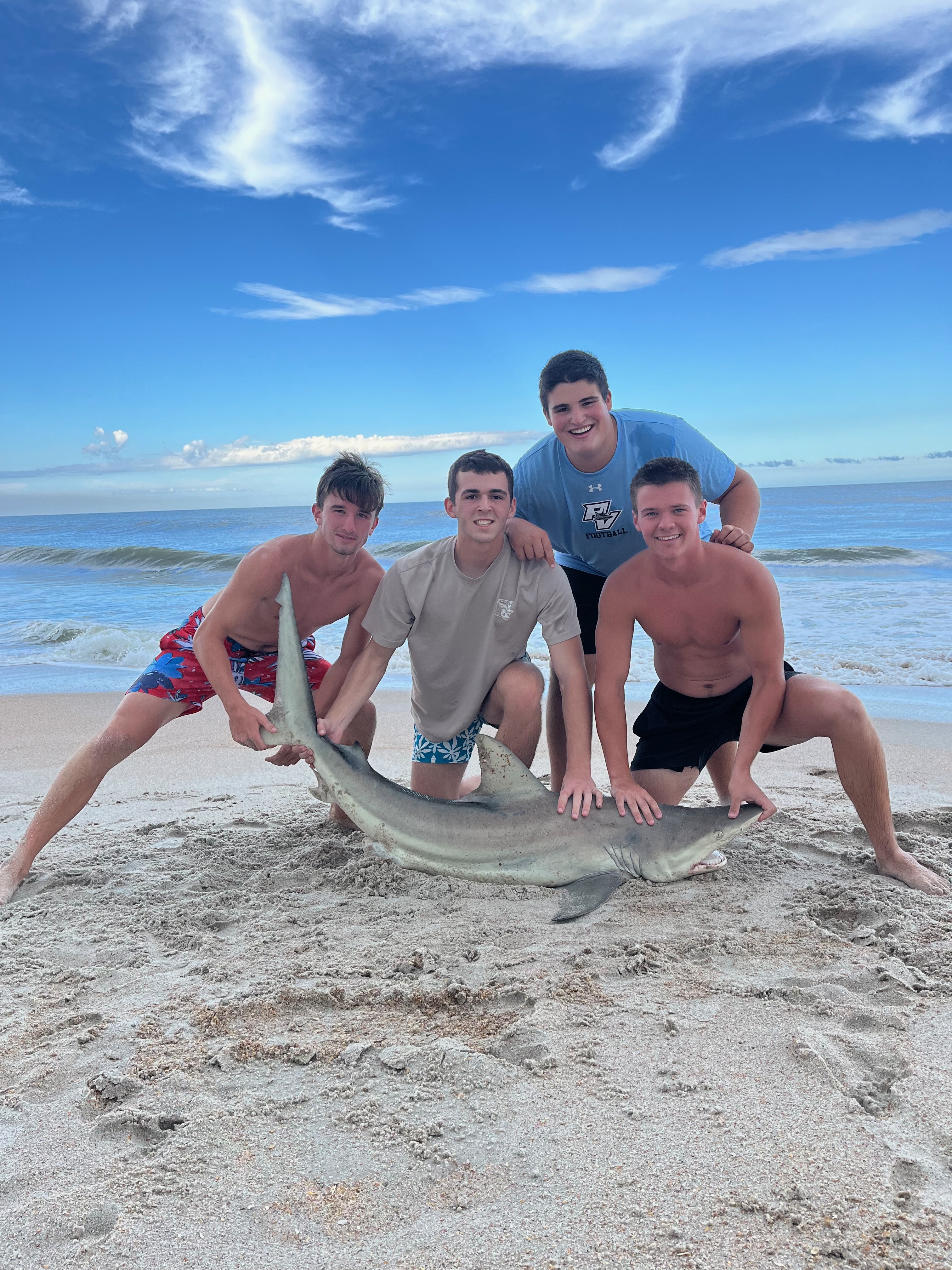 Bite Club crew with a shark catch on the beach